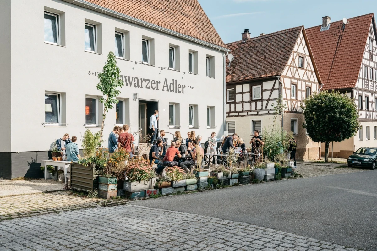 Besucher genie&szlig;en die Atmosph&auml;re vor dem Schwarzer Adler.