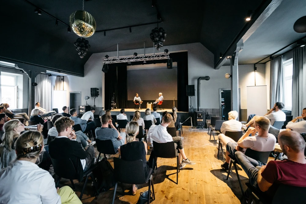 Veranstaltung im Schwarzer Adler mit Publikum und Diskussionsrunde.