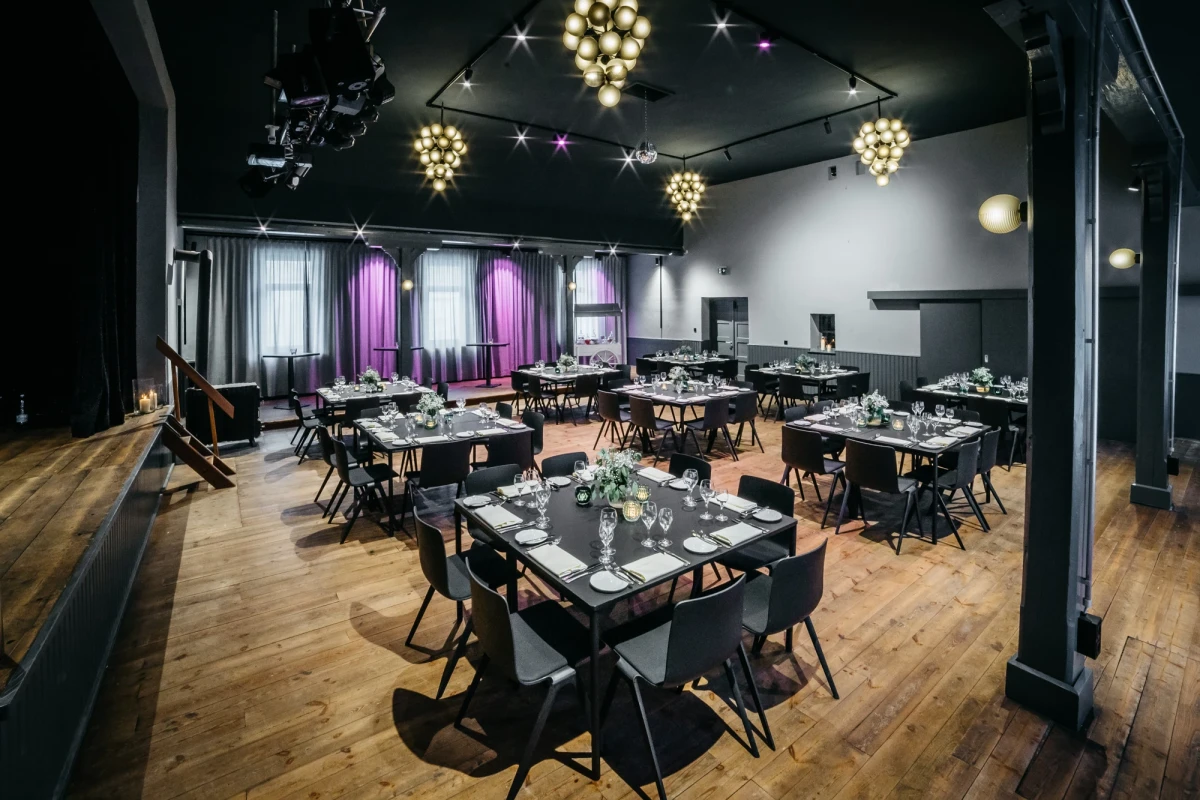 Eleganter Festsaal mit festlich gedeckten Tischen und Beleuchtung.